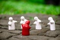 4 white ceramic dolls ÃÂ But there is 1 red one, green background with bokeh